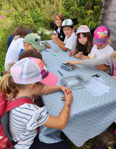 Kinder basteln eine Erinnerung an ihren Kindergeburtstag bei Schönenberg Alpakas im Mindeltal, Bayern.