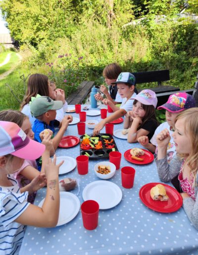 Kinder essen und feiern im Freien.